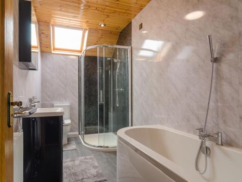 a bathroom with a tub and a shower and a sink at Avoca Lodge in Lisburn