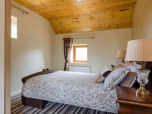 a bedroom with a bed and a wooden ceiling at Avoca Lodge in Lisburn