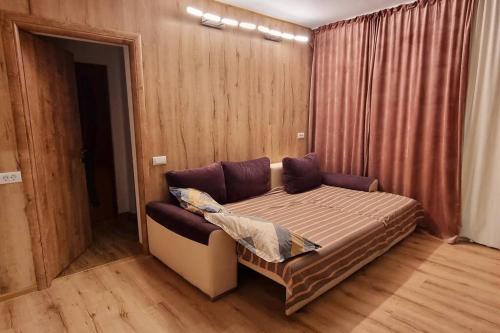 a bedroom with a bed with a couch in it at Urban Retreat Barlad in Bîrlad