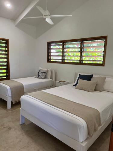 a bedroom with two beds and two windows at Lope Lope Beach Bungalows in Luganville