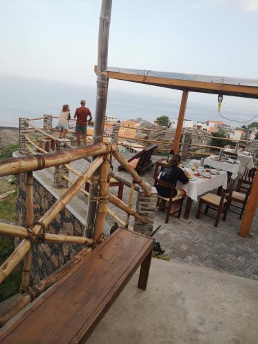 a restaurant with tables and benches on top of a building at Kaza Ladera in Seladinha