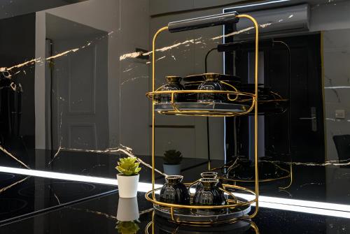 a black and gold stand with pots and vases on it at Golden Greens Studio - Luxury Design & Self Check-in in Braşov