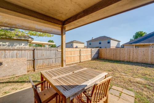 a patio with a wooden table and chairs and a fence at Private Yard and Patio Fort Worth Family Home in Fort Worth