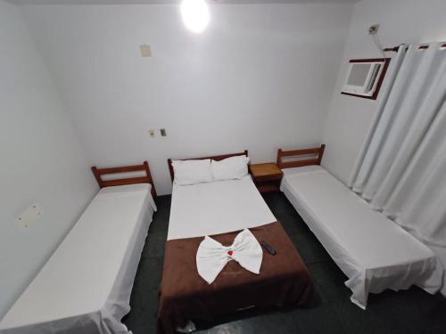 two beds in a small room with white walls at Pousada da Jaqueira - EPP in Rio das Ostras