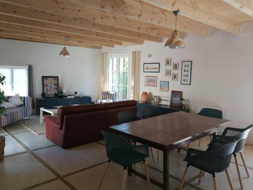 - un salon avec un canapé, une table et des chaises dans l'établissement Charmante maison dans joli village, à Vouhé