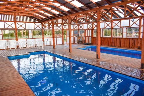 uma grande piscina interior com telhado de madeira em Parques de Afunalhue em Licán Ray