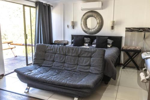 a living room with a couch and a mirror at Old Mill Lodge, Seasonal Working Ostrich Farm & Restaurant, Oudtshoorn in Oudtshoorn