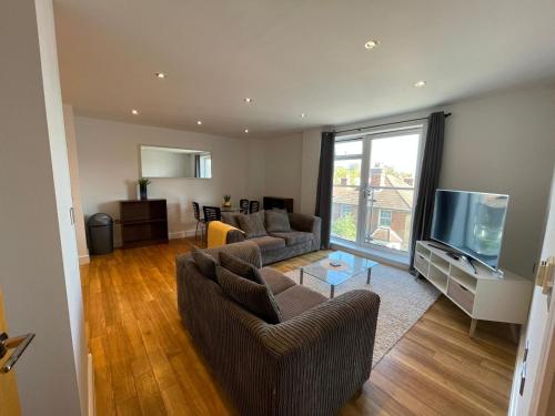 a living room with two couches and a flat screen tv at Blue Sky Apartments@ Abbots Yard, Guildford in Guildford