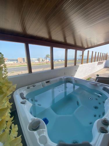 a hot tub on a patio with a view of the beach at Beach Villa private heated pool in Caleta De Fuste