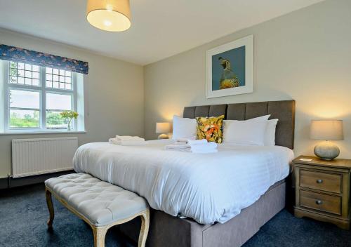 1 dormitorio con 1 cama grande y 1 silla en Gardeners Cottage - Nowton Park en Rushbrooke