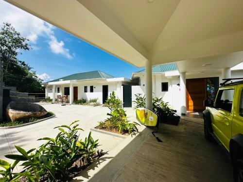 a yellow car parked in front of a house at Villa Club Tropicana Carana with infinity pool in Machabee