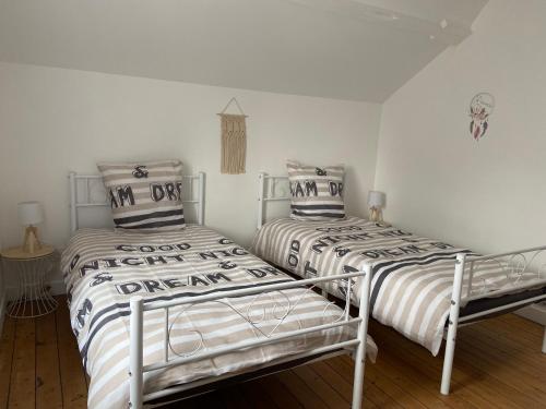 twee bedden naast elkaar in een slaapkamer bij Charmante maison entièrement rénovée cœur de ville in Blois