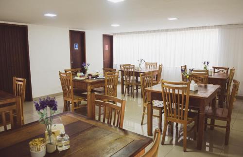 a dining room with wooden tables and chairs at Pousada Xerxes in Arraial do Cabo