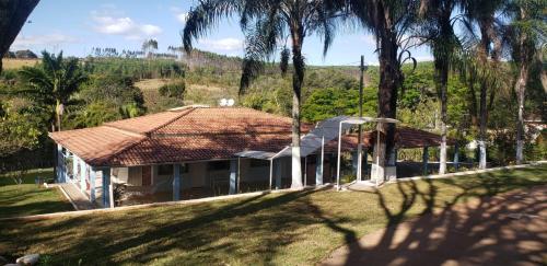 a house with a tiled roof and palm trees at Pousada Oásis 2 in Fama