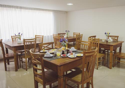 a dining room with wooden tables and chairs at Pousada Xerxes in Arraial do Cabo