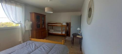 a bedroom with a bed and a room with a desk at Aux Grisolles in Millau
