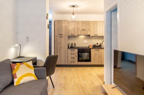 uma sala de estar com um sofá e uma cozinha em Kirabela Apartment em Zagreb