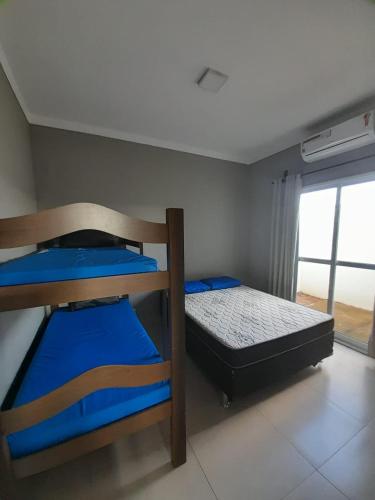 two bunk beds in a room with a window at Vila Caluca Olimpia - Flats & Suites in Olímpia