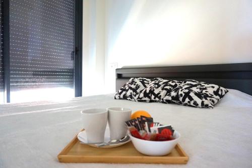 - un plateau avec 2 tasses et un bol de fruits sur le lit dans l'établissement Moderno apartamento en el Campello by beBalmy, à El Campello