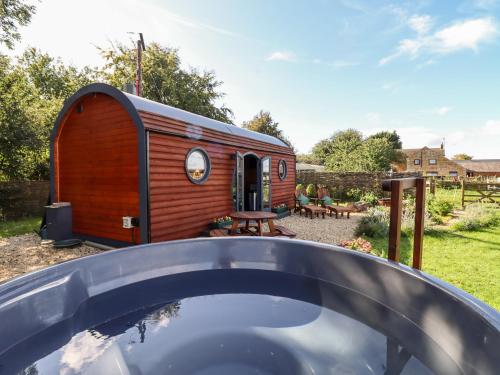 a wooden shed with a pool in a yard at The Happy Valley Pod in Chipping Norton