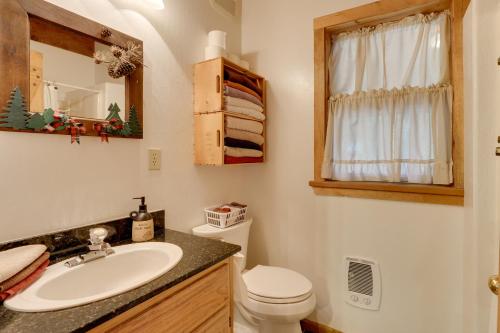 a bathroom with a sink and a toilet and a mirror at Pet-Friendly House with Deck Near Crater Lake! in Fort Klamath