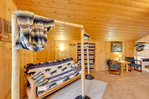 Fort KlamathにあるPet-Friendly House with Deck Near Crater Lake!のログキャビン内のベッド1台が備わる客室です。