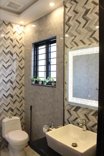 La salle de bains est pourvue d'un lavabo, de toilettes et d'un miroir. dans l'établissement Vacation Villa, à Lahore