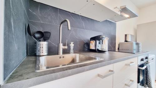 a kitchen counter with a sink in a kitchen at Chez JM - Calme - Chic - Fibre - Relax BNB in Mulhouse