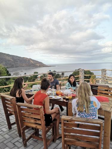 a group of people sitting at a table at Kaza Ladera in Seladinha