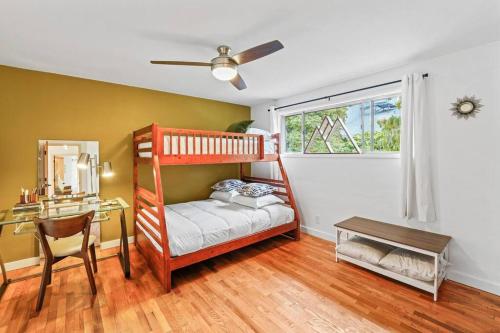 1 Schlafzimmer mit Etagenbetten, einem Schreibtisch und einem Fenster in der Unterkunft The Jasmine House in Eugene