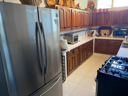 uma cozinha com um frigorífico de aço inoxidável e um fogão em Coronado Beachfront tropical home! em Playa Coronado