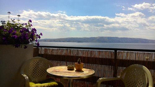a table on a balcony with a view of the water at Apartment and Rooms Busa 3 in Senj