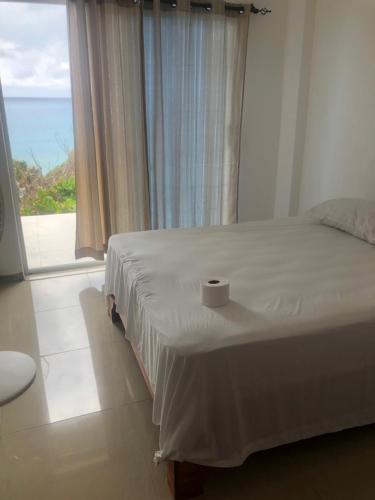 Un dormitorio con una cama con una vela. en Hotel Alto Velo Beach, en Bejuquero