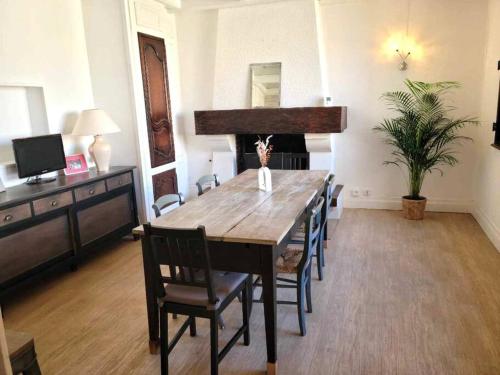 une salle à manger avec une table et des chaises en bois dans l'établissement Idéal centre Vichy, bel appartement F5, à Vichy