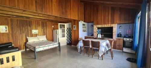 a kitchen with wooden walls and a table and chairs at Monoambiente Cañuelas Centro calle Principal hasta 4 personas in Cañuelas