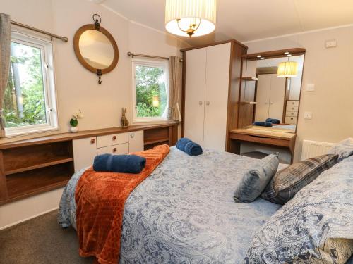 1 dormitorio con cama y espejo en Loch Lomond Holiday Home, en Arrochar