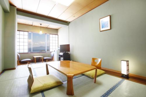 a living room with a wooden table and chairs at Ibusuki Seaside Hotel in Ibusuki