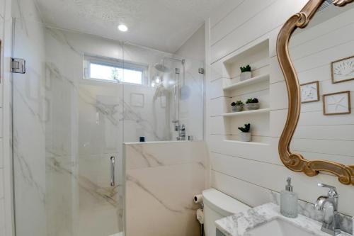 a white bathroom with a shower and a sink at Spacious Winder Getaway with Hot Tub and Game Room! in Winder