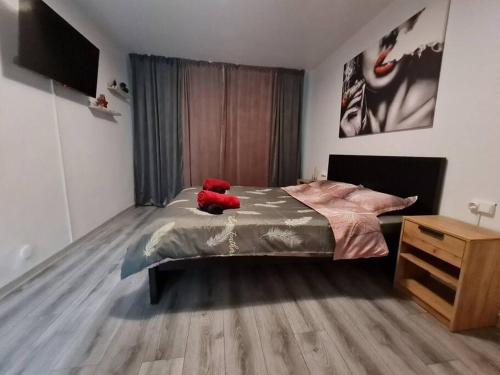 a red teddy bear sitting on a bed in a bedroom at Urban Nest Barlad in Bîrlad