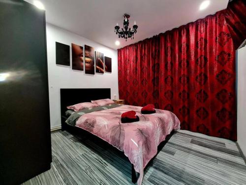 sypialnia z łóżkiem i czerwoną zasłoną w obiekcie Urban Nest Barlad w mieście Bîrlad