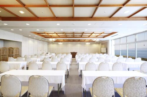 a conference room with white tables and chairs at Ibusuki Seaside Hotel in Ibusuki