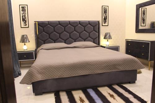 Vacation Villa في لاهور: غرفة نوم بسرير كبير مع مواقف ليلتين