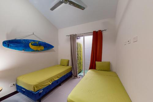 une chambre avec 2 lits et une planche de surf sur le mur dans l'établissement Ciudad del Mar#20, à Jacó