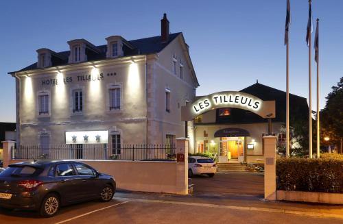 a car parked in a parking lot in front of a building at Hôtel Les Tilleuls, Bourges in Bourges