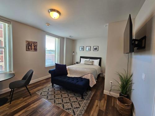 a bedroom with a bed and a chair and a television at Cozy Stay at the Inman - 214 in Champaign