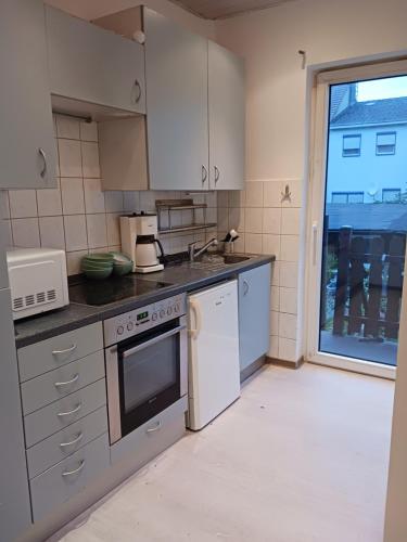 una cocina con electrodomésticos blancos y una ventana en adasflats, en Bremen