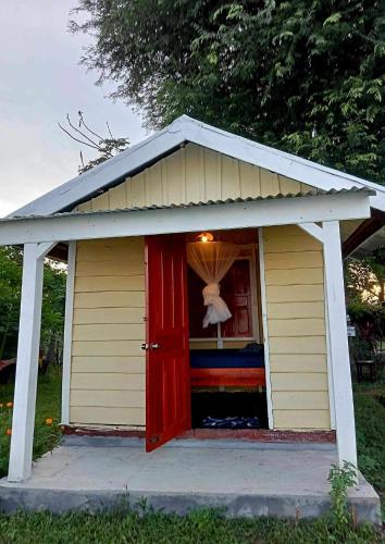 a small house with a red door on a porch at Don Som Riverside Guesthouse in Don Som