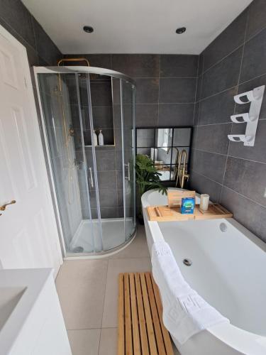 a bathroom with a bath tub and a shower at LUTON AIRPORT PROFESSIONALS CONTRACTORS Beds Uni students Welcome in Luton