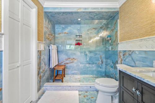 baño con aseo y pared de azulejos azules en Leisure Beach Ocean Retreat, en Lower Bogue