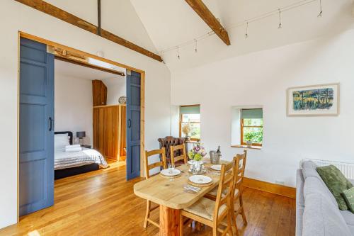 a dining room with a table and a couch at The Haybarn in Dundrennan